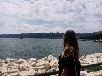 Woman looking at sea against sky