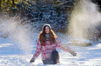 Playful teenage girl on snow covered field