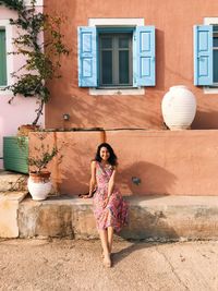 Portrait of woman standing against building