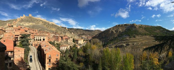 Panoramic view of buildings and mountains against sky