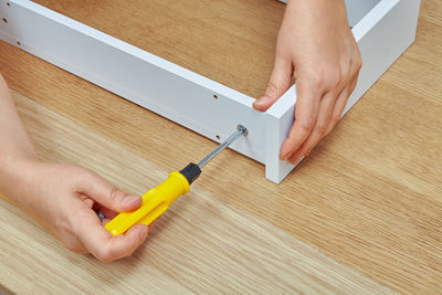 Close-up of person working on wooden table