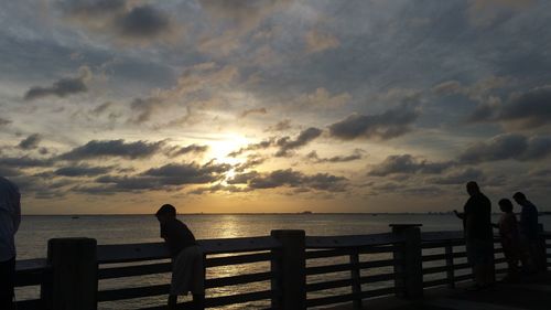 Scenic view of sea against cloudy sky during sunset