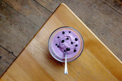 Directly above shot of yogurt with blueberry in glass on table