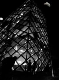 Low angle view of silhouette man against illuminated sky at night