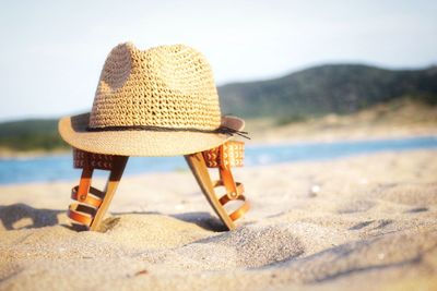 Lounge chairs on sand at beach against sky