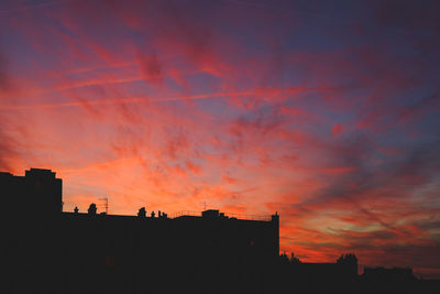 Silhouette city against sky during sunset