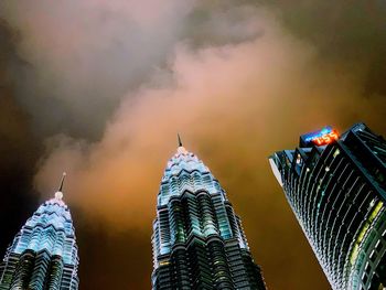 Low angle view of modern buildings against cloudy sky