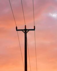 Low angle view of silhouette electricity pylon against sky during sunset