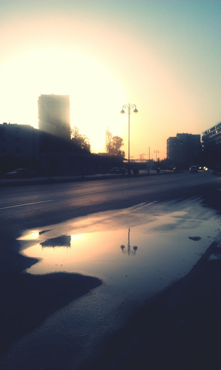 building exterior, architecture, built structure, transportation, sunset, water, street light, sky, clear sky, mode of transport, silhouette, sun, copy space, reflection, outdoors, illuminated, nature, city, dusk, sunlight