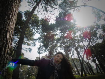 Portrait of young woman against trees