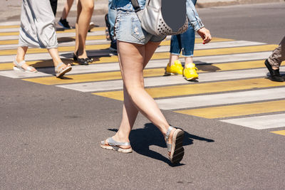 Low section of women walking on road