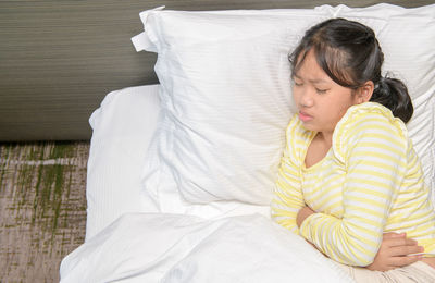 Midsection of woman sleeping on bed