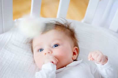 Portrait of cute baby lying on bed