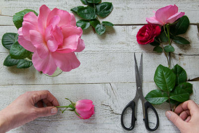 Cropped image of florist holding flowers on table