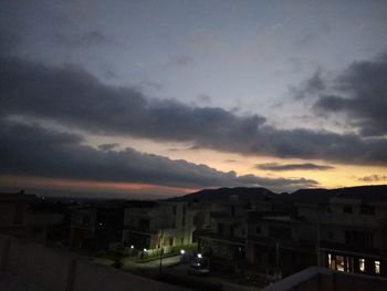 Buildings in city against sky at sunset