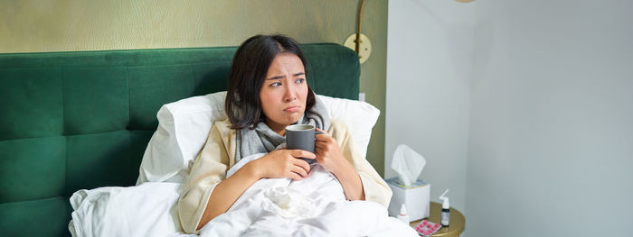 Portrait of young woman sitting at home