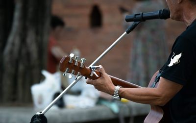 Midsection of man playing guitar