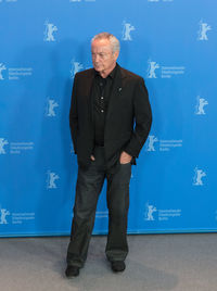 Full length of man standing against blue wall