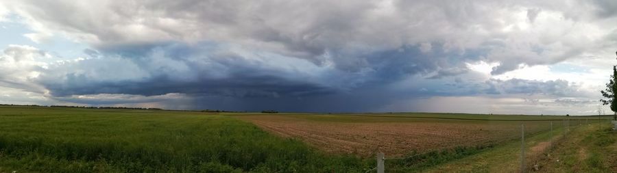 Panoramic view of agricultural field against sky