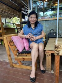 Portrait of a smiling young woman sitting on seat