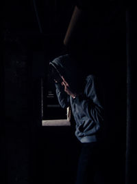 Man standing in illuminated dark room