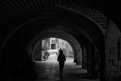 Rear view of woman walking in corridor of building