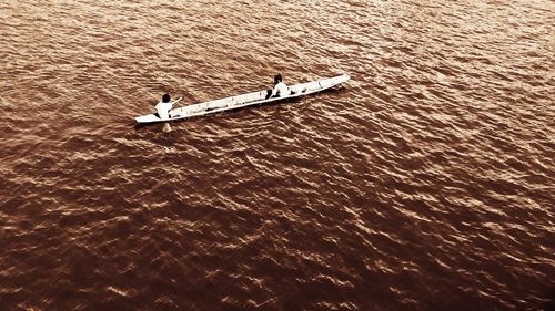 Boat sailing in water at sunset