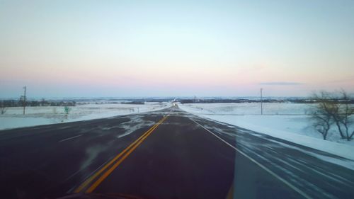 Highway against clear sky during sunset