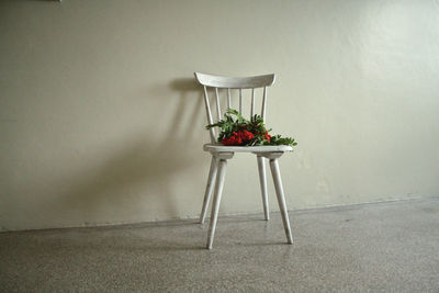 Empty chair on table against wall