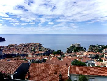 High angle view of townscape by sea against sky