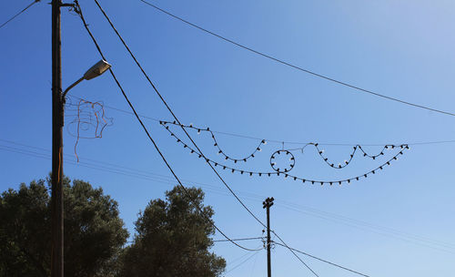 Low angle view of birds flying against clear blue sky