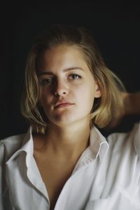 Portrait of a beautiful young woman over black background