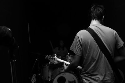 Rear view of man playing at music concert