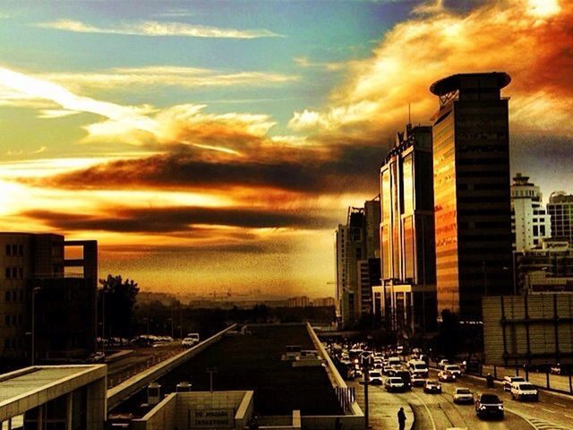 sunset, building exterior, architecture, built structure, city, transportation, sky, car, mode of transport, orange color, cloud - sky, land vehicle, cityscape, city life, street, building, high angle view, cloud, cloudy, road