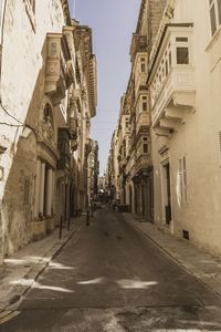 Empty road amidst buildings in town