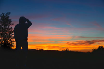 Silhouette man standing against sky during sunset