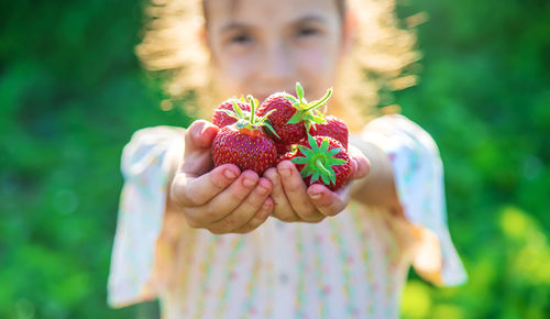 Girl showing strawberries