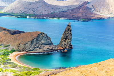 Pinnacle rock in sea at bartolome island