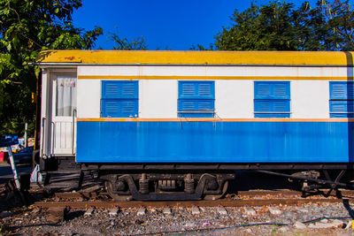 Train by railroad tracks against clear blue sky
