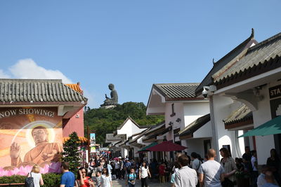 Group of people in traditional building against sky