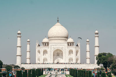 Group of people in front of building against clear sky. the taj mahal