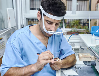 Close-up of dental worker cleaning dentures