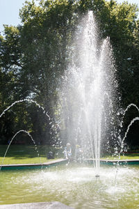 Water splashing in fountain against trees