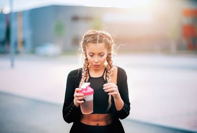 Portrait of young woman drinking water