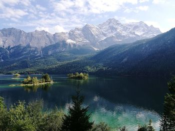 Scenic view of lake by mountains against sky