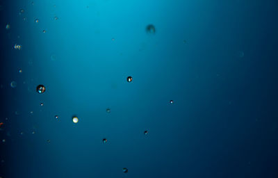 Low angle view of bubbles against blue sky