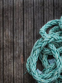 Close-up of rope tied on wooden plank