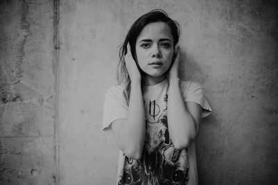 Portrait of woman standing against wall