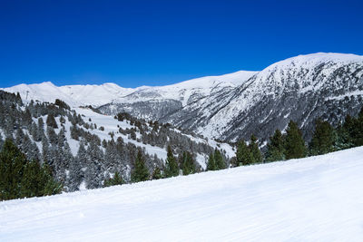 Scenic view of snowcapped mountains against clear blue sky