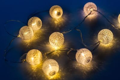 Low angle view of illuminated lights against sky at night